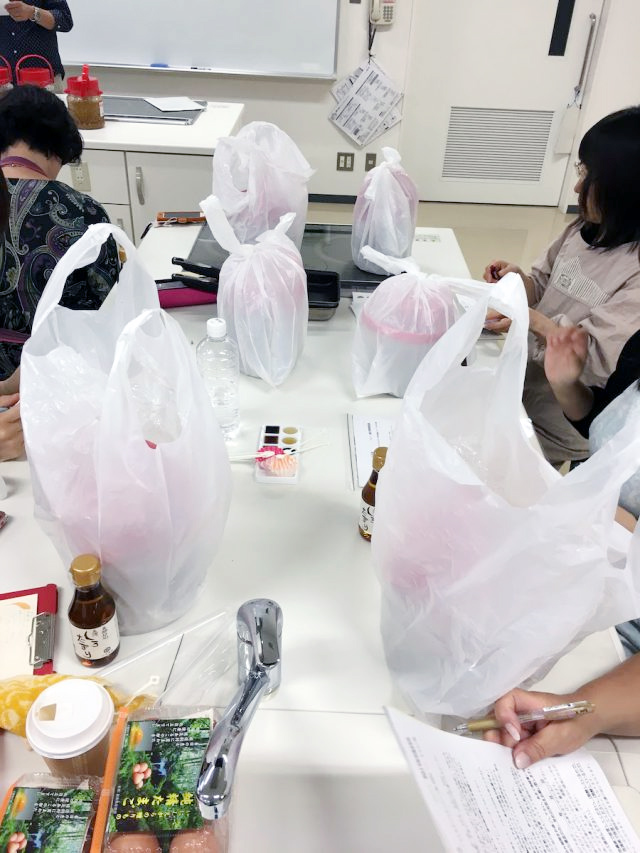 容器をビニール袋に入れて持ち帰る