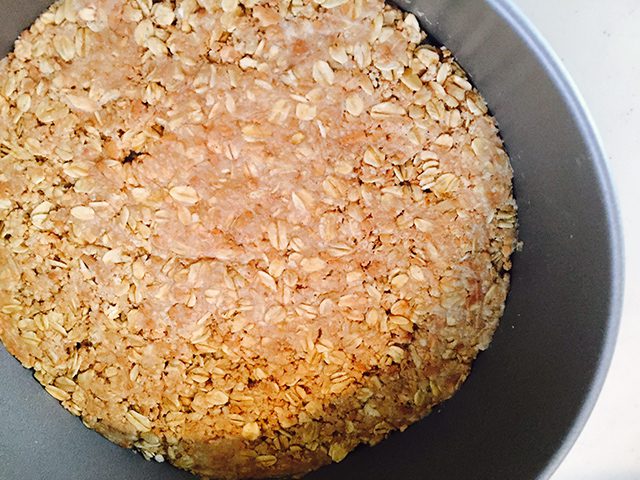 オートミールに豆乳を加えて全体的にしっとりするまで混ぜ、ケーキ型に平らに押しながら敷き詰めます