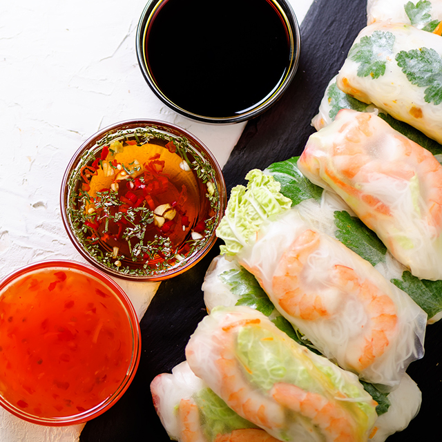 Vietnamese spring rolls - rice paper, lettuce, salad, vermicelli, noodles, shrimps, fish sauce, sweet chili, soy, lemon, veletables. Copy space. Asian and thai food. Traditional national cuisine.