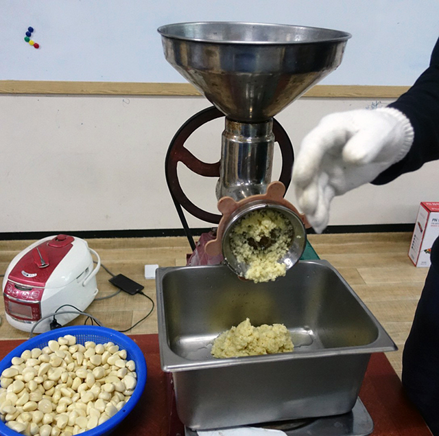 ショウガは皮をこそげ落とし、玉ネギやニンニク、梨はざく切りにして機械でペーストにしていく