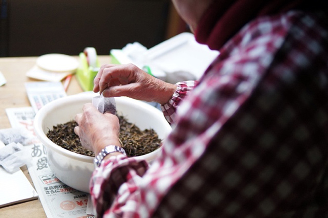 作業場で阿波晩茶をティーバッグに詰める山田さん