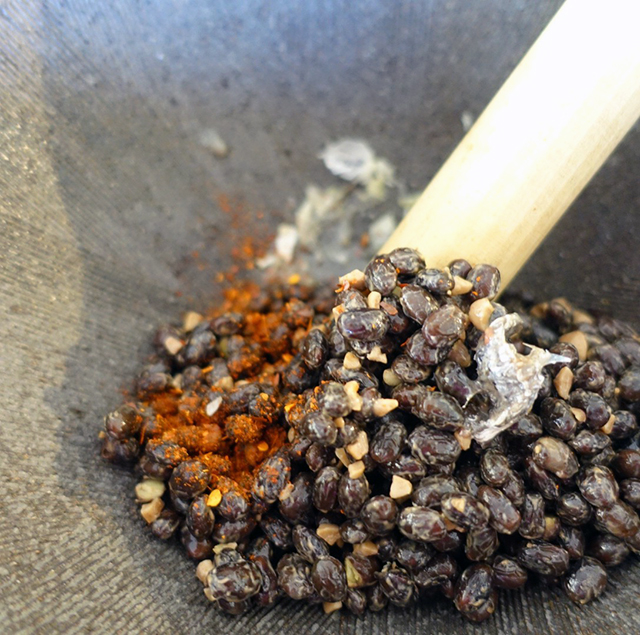 すり鉢にまずニンニクを入れて潰し、トナオ、 唐辛子、魚醤、塩を入れすりこぎで潰す。